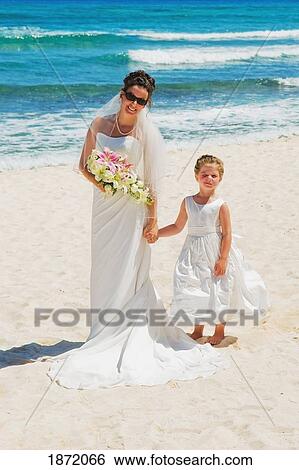 Stock Photograph - akumal, riviera maya, mexico; a bride and a young girl on the beach at gran bahia principe tulum all-inclusive resort. Fotosearch