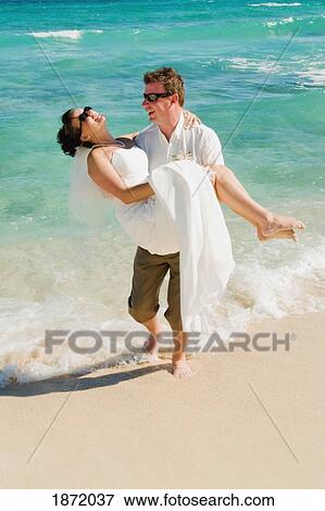 akumal, riviera maya, mexico; a groom carrying the bride on the beach at gran bahia principe tulum all-inclusive resort View Large Photo Image Stock Photo - akumal, riviera maya, mexico; a groom carrying the bride on the beach at gran bahia principe tulum all-inclusive resort. Fotosearch