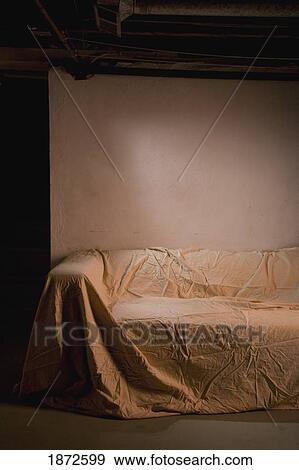 Stock Photo - an abandoned couch covered with a sheet. Fotosearch