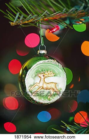 Picture - an ornament with a reindeer hanging from a christmas tree. Fotosearch