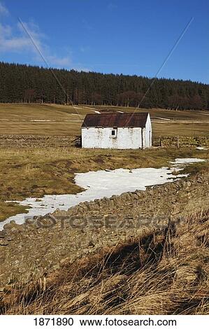 Stock Image - durham dales, county dales, england; a building and fence with traces of snow on the ground. Fotosearch