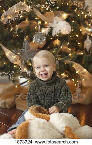 jordan, ontario, canada; a toddler sitting beside the christmas tree laughing View Large Photo Image Picture - jordan, ontario, canada; a toddler sitting beside the christmas tree laughing. Fotosearch