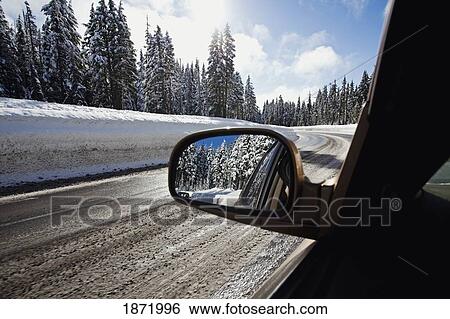 Stock Photograph - oregon cascades, oregon, united states of america; view from a car's side mirror on the road and fresh winter snow on mount hood. Fotosearch