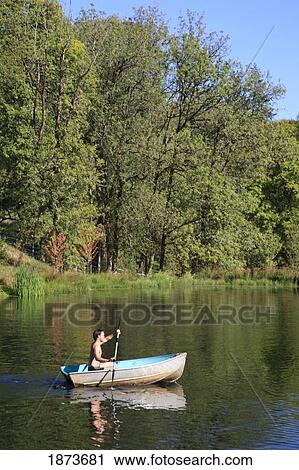 Stock Image - portland, oregon; a young man rowing a boat on a lake. Fotosearch