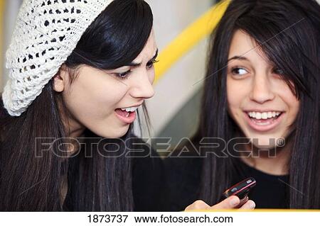 Stock Photo - portland, oregon, united states of america; two teenage girls using a cell phone. Fotosearch