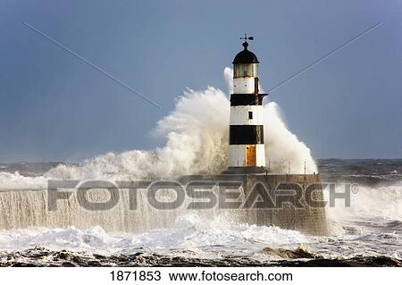 Stock Image - seaham, teesside, england; waves crashing against a lighthouse. Fotosearch