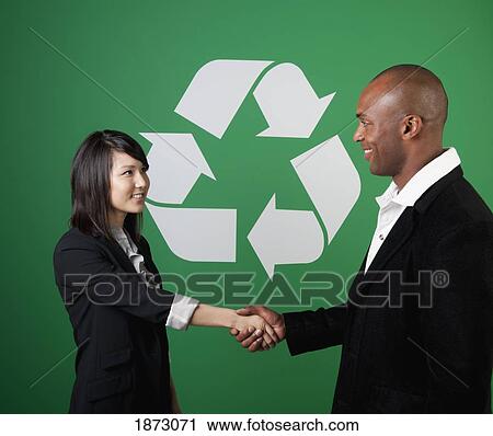 two business people shaking hands in front of a recycle symbol View Large Photo Image Stock Image - two business people shaking hands in front of a recycle symbol. Fotosearch