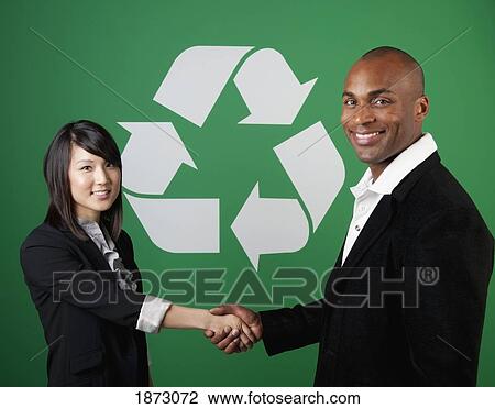 two business people shaking hands in front of a recycle symbol View Large Photo Image Stock Image - two business people shaking hands in front of a recycle symbol. Fotosearch