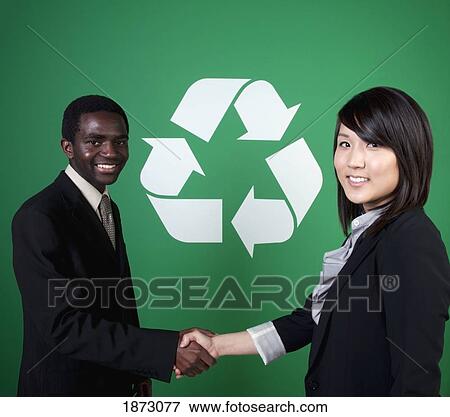 two business people shaking hands in front of a recycle symbol View Large Photo Image Stock Photo - two business people shaking hands in front of a recycle symbol. Fotosearch