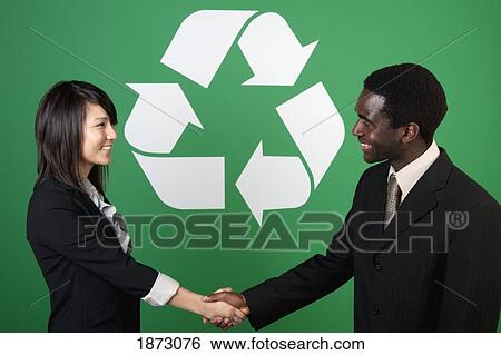 two business people shaking hands in front of a recycle symbol View Large Photo Image Stock Photograph - two business people shaking hands in front of a recycle symbol. Fotosearch