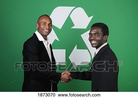 two businessmen shaking hands in front of a recycle symbol View Large Photo Image Stock Image - two businessmen shaking hands in front of a recycle symbol. Fotosearch