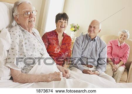 Picture - visiting an elderly father in the hospital. Fotosearch