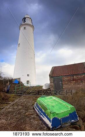 Stock Image - whitley bay, northumberland, england; a boat on the shore and st. mary's lighthouse. Fotosearch