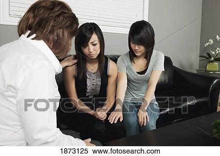 Stock Photography - women praying for a young woman. Fotosearch