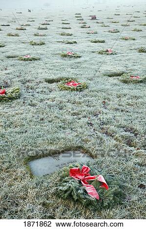 Stock Image - wreaths in front of grave markers in a cemetery. Fotosearch