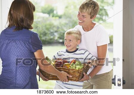 a boy and his mother giving a basket of fruit View Large Photo Image Stock Image - a boy and his mother giving a basket of fruit. Fotosearch