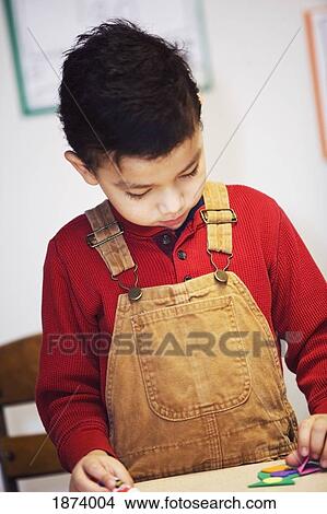 Picture - a boy doing a craft at the table. Fotosearch