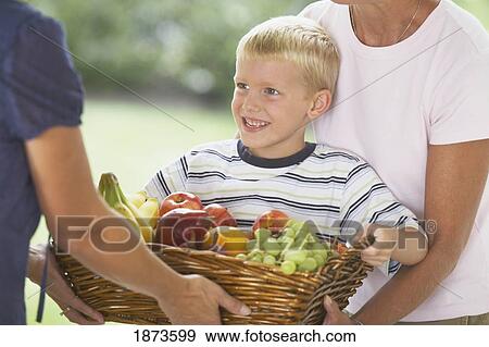a boy giving a basket of fruit View Large Photo Image Stock Photo - a boy giving a basket of fruit. Fotosearch