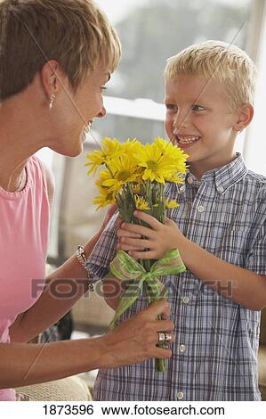 a boy giving flowers to his mother View Large Photo Image Stock Photograph - a boy giving flowers to his mother. Fotosearch