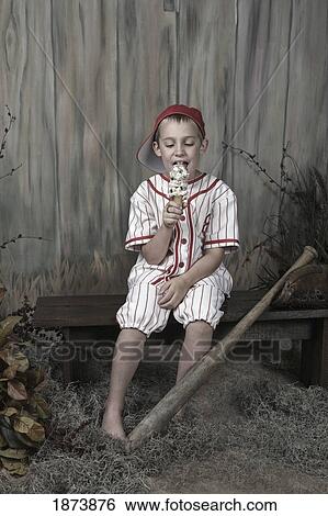 a boy wearing a baseball uniform and eating an ice cream cone View Large Photo Image Stock Photograph - a boy wearing a baseball uniform and eating an ice cream cone. Fotosearch
