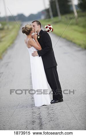 a bride and groom kissing in the middle of the road View Large Photo Image Stock Photography - a bride and groom kissing in the middle of the road. Fotosearch