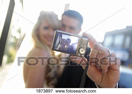 a bride and groom taking a self portrait with a camera View Large Photo Image Stock Photo - a bride and groom taking a self portrait with a camera. Fotosearch