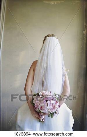 Picture - a bride holding her floral bouquet. Fotosearch