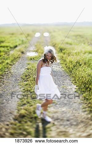 a bride standing on a dirt road in a field View Large Photo Image Stock Photograph - a bride standing on a dirt road in a field. Fotosearch