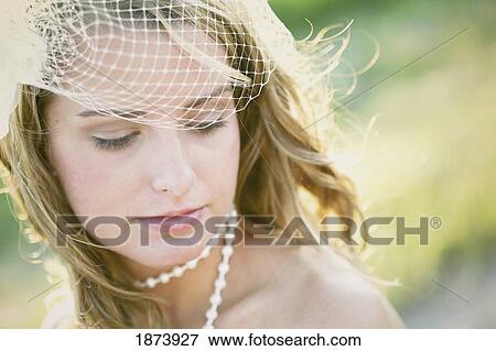 Stock Photo - a bride wearing a veil and a pearl necklace. Fotosearch