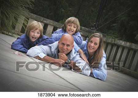 a family portrait with members laying down on the deck View Large Photo Image Picture - a family portrait with members laying down on the deck. Fotosearch