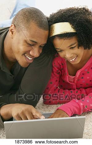a father and daughter working on a laptop computer View Large Photo Image Stock Photograph - a father and daughter working on a laptop computer. Fotosearch