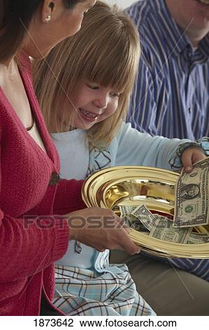 a girl putting money in the collection plate View Large Photo Image Stock Image - a girl putting money in the collection plate. Fotosearch