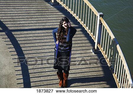 a girl standing beside a railing along the water View Large Photo Image Stock Photo - a girl standing beside a railing along the water. Fotosearch