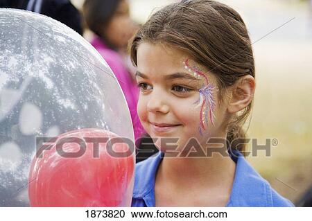 a girl with her face painted holding a balloon View Large Photo Image Stock Image - a girl with her face painted holding a balloon. Fotosearch