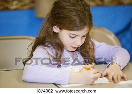 a girl writing on paper at the table View Large Photo Image Stock Image - a girl writing on paper at the table. Fotosearch
