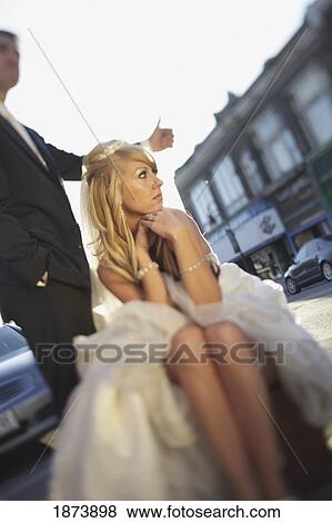 a groom hitch hiking and the bride sitting on the side of the road View Large Photo Image Stock Photo - a groom hitch hiking and the bride sitting on the side of the road. Fotosearch