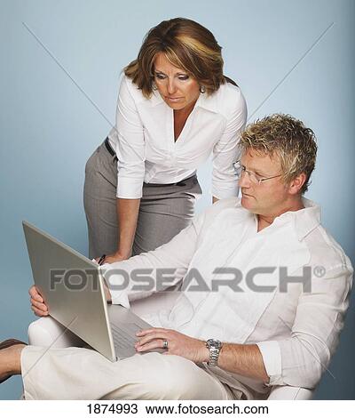 Stock Image - a man and woman looking at a laptop computer. Fotosearch