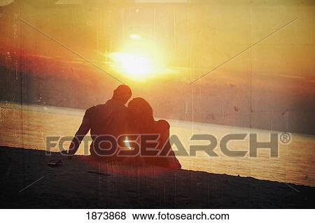 a man and woman sitting on the beach in a sunset View Large Photo Image Stock Photo - a man and woman sitting on the beach in a sunset. Fotosearch