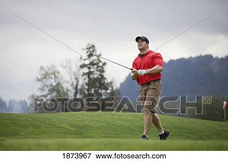 Stock Photo - a man golfing on a golf course. Fotosearch