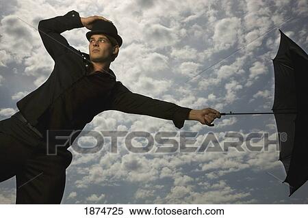 a man holding an umbrella and wearing a top hat View Large Photo Image Stock Photography - a man holding an umbrella and wearing a top hat. Fotosearch