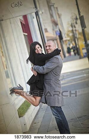 Stock Image - a man lifting a woman while in an embrace. Fotosearch