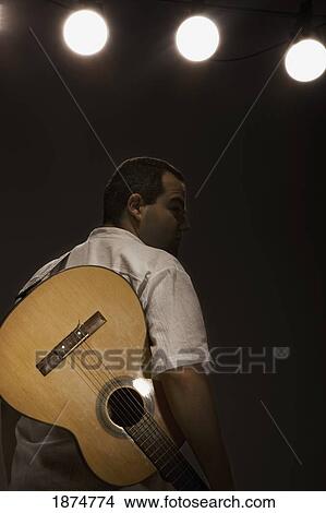 a man with a guitar on a strap View Large Photo Image Picture - a man with a guitar on a strap. Fotosearch
