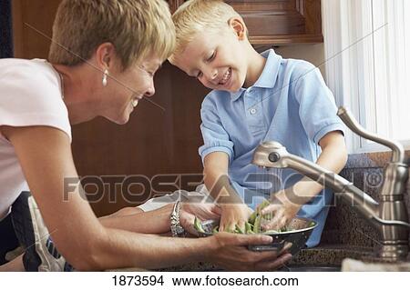 a mother and son washing vegetables View Large Photo Image Picture - a mother and son washing vegetables. Fotosearch