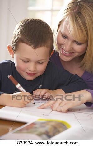 Picture - a mother doing workbook activities with her son. Fotosearch