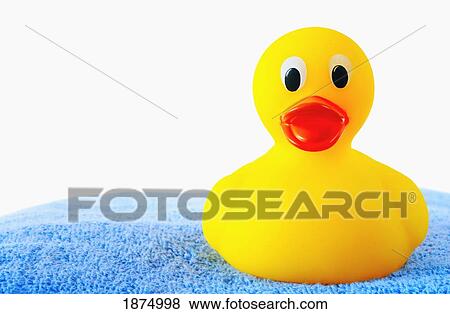 Stock Photo - a rubber duck sitting on a blue bath towel. Fotosearch