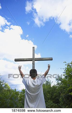 a teenage boy with arms raised towards the cross View Large Photo Image Stock Photo - a teenage boy with arms raised towards the cross. Fotosearch