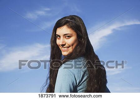 a teenage girl against a blue sky View Large Photo Image Stock Image - a teenage girl against a blue sky. Fotosearch