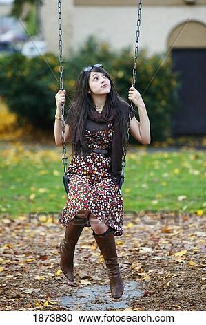a teenage girl sitting on a swing View Large Photo Image Stock Image - a teenage girl sitting on a swing. Fotosearch