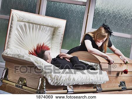 a woman mourning at a coffin where a deceased young man lays View Large Photo Image Stock Photo - a woman mourning at a coffin where a deceased young man lays. Fotosearch