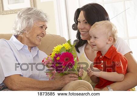 a young child giving flowers to his grandmother View Large Photo Image Stock Photography - a young child giving flowers to his grandmother. Fotosearch